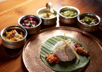 A close-up of a delicious Sri Lankan meal, with rice, curries, and other accompaniments arranged on a plate.